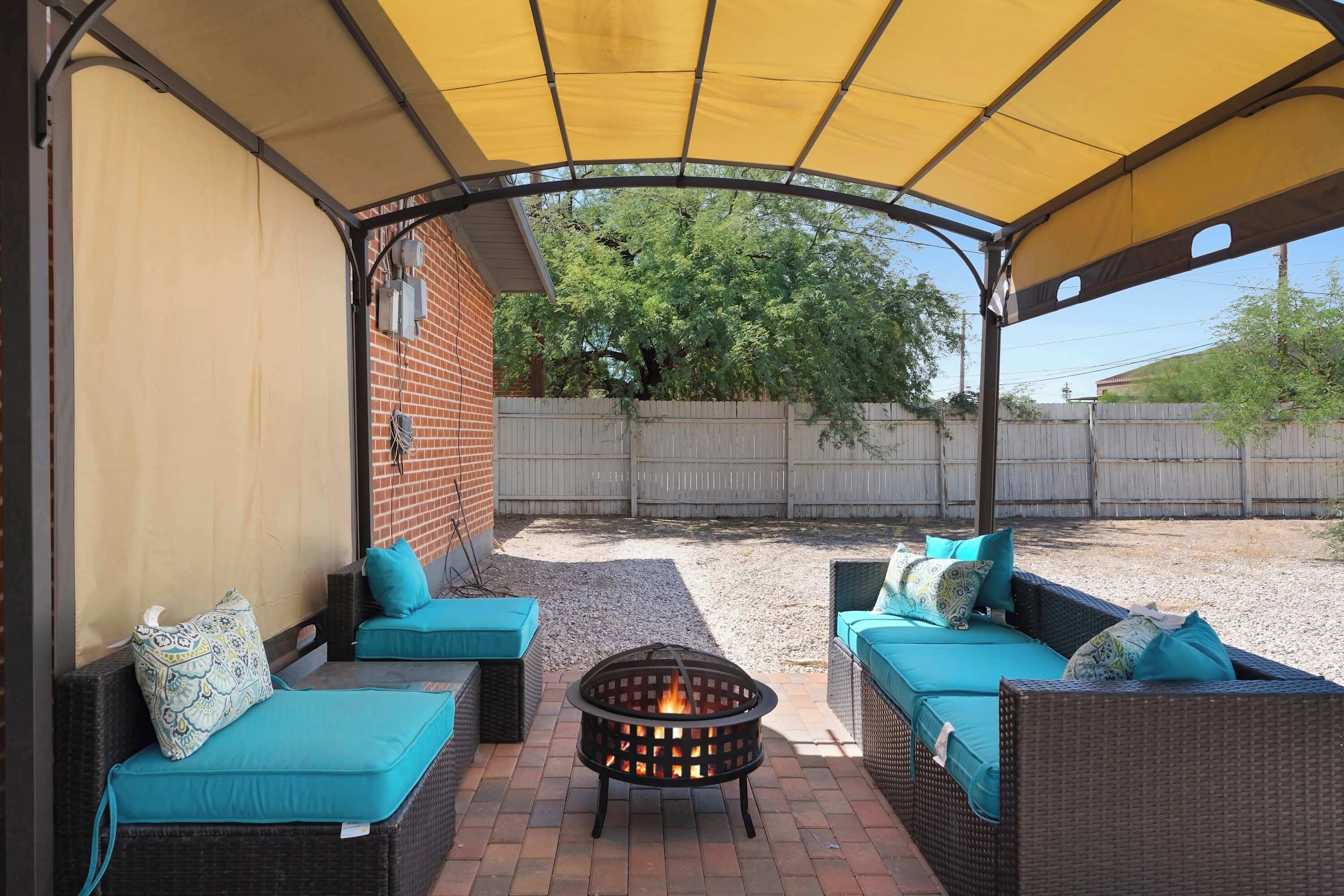 Un patio al aire libre con mobiliario de mimbre y una chimenea.