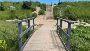 Une promenade en bois menant à un escalier dans un cadre naturel.