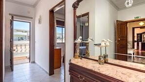 A hotel hallway with a marble counter, wooden doors, and a large mirror reflecting a balcony view. - New Sunset Haven in Gale-2br With Big Terrace (Albufeira)
