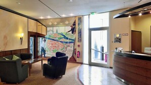 Un vestíbulo con mostrador de recepción, zona de estar y un gran mural de un mapa en la pared.