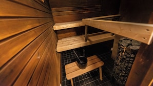 Una sauna con bancos de madera y una pared de piedra.