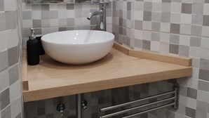 A bathroom with a white sink, a mirror, a window, and a tiled backsplash. - Trastevere Cottage (Roma)