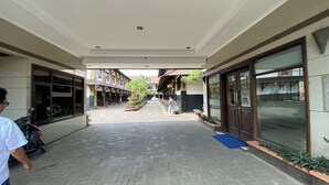 A covered walkway leading to a building with a sign indicating a restaurant.