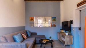 Ein modernes Wohnzimmer mit einer Eckcouch, einem Couchtisch, einem Fernseher und einem dekorativen Spiegel.