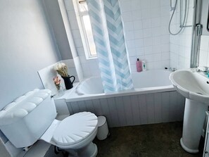 Een haardroger, handdoeken, shampoo, toiletpapier