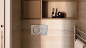 A bathroom with a wooden vanity, a towel rack, and a towel hanging on it.