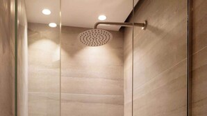A glass-enclosed shower with a handheld showerhead and a wall-mounted control. - Charming modern Studio with AC - Le Marais (Paris)