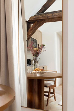 A dining area with a wooden table, a vase with flowers, and a chair. - Charming flat - AC - 2BR-6P- le Marais (Paris)