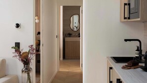 A modern kitchen with wooden cabinets, a white countertop, and a built-in microwave. - Charming flat - AC - 2BR-6P- le Marais (Paris)