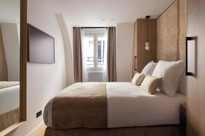 A modern hotel room with a large bed, a mirror, a flat-screen TV, and a view of the balcony. - Charming flat - AC - 2BR-6P- le Marais (Paris)