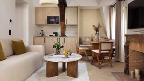 A modern living room with a sofa, coffee table, and dining area. - Charming flat - AC - 2BR-6P- le Marais (Paris)