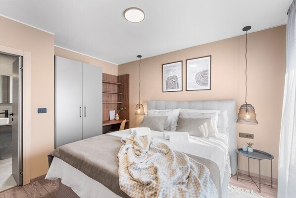 A modern bedroom with a bed, bedside tables, a wardrobe, and artwork on the wall. - Luxurious Apartment with Jacuzzi, Sea View, and Balcony in Istria (Brtonigla)