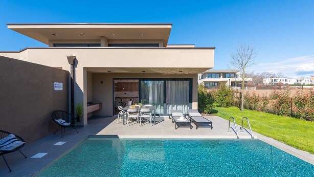 A modern house with a swimming pool, outdoor seating, and a view of neighboring buildings. - Ground-Floor Apartment with Private Pool and Terrace in Istria, 150 Meters from the Sea (Brtonigla)