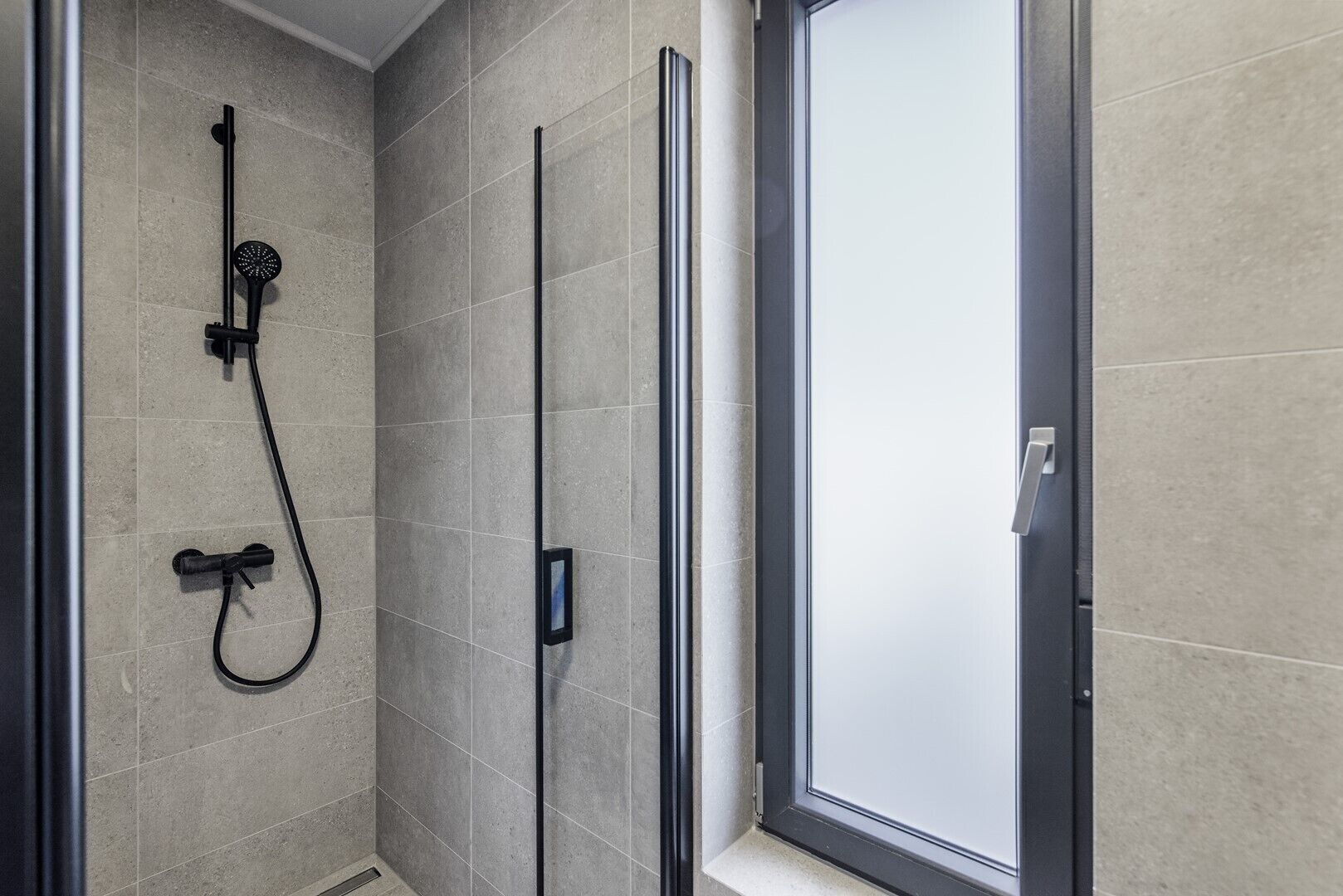Ein modernes Badezimmer mit Dusche, Toilette und Glastür.