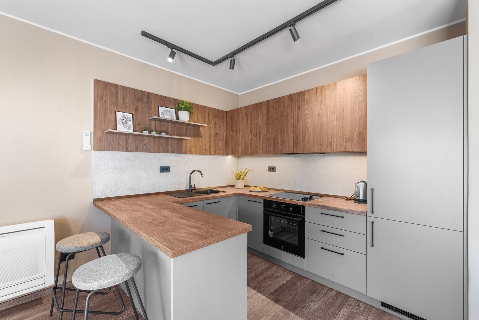 Una cocina moderna con una isla central, armarios de madera y electrodomésticos integrados.