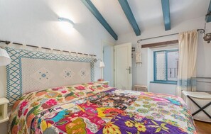 A bedroom with a colorful quilt, a bed with a headboard, a window with curtains, and a door. - Charming City-Center Cottage Just 20 Meters from the Beach in Novigrad (Novigrad)