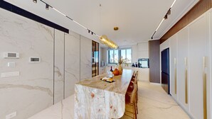 A modern kitchen with a marble countertop, built-in appliances, and a large window providing a view of the city. - Exclusive King David Penthouse-4BR &breathtaking views! (Jerusalem)
