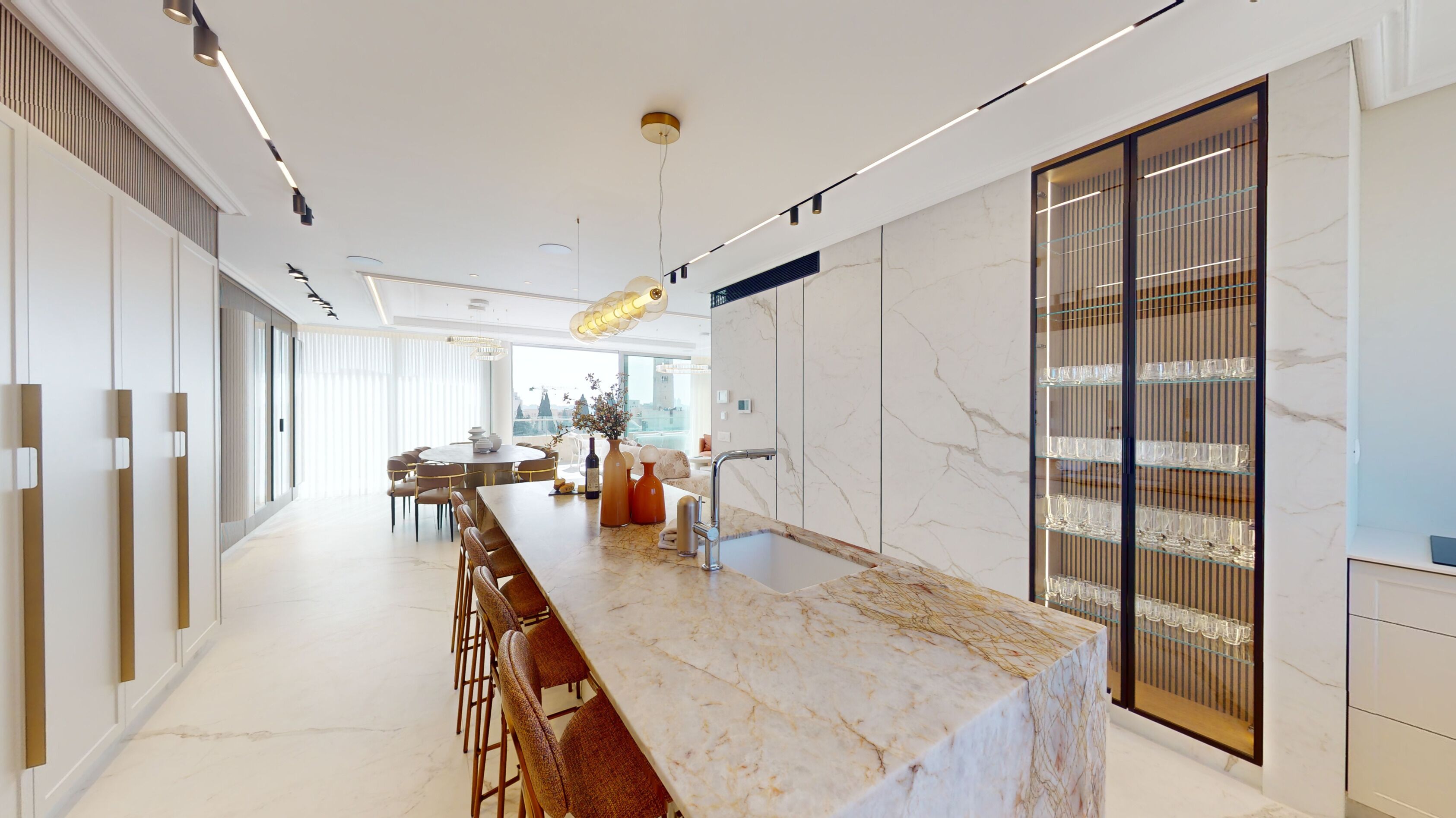 A modern kitchen with a marble countertop, a built-in wine rack, and a dining area with a round table and chairs.
