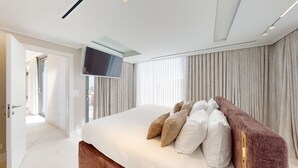 A modern bedroom with a large bed, a flat-screen TV, and a view of the outdoors through a sliding door. - Exclusive King David Penthouse-4BR &breathtaking views! (Jerusalem)