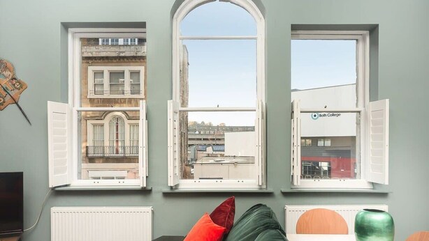 Ein Zimmer mit drei Fenstern, jedes mit einem anderen Ausblick.