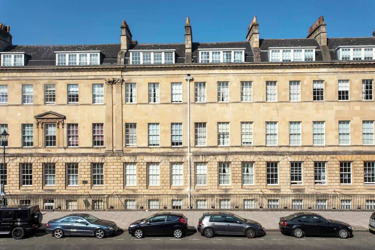 A row of historic buildings with uniform windows and a central entrance.