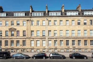 Una hilera de edificios históricos con ventanas uniformes y una entrada central.