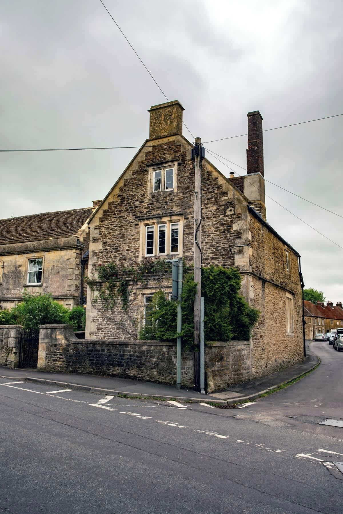 Un bâtiment en pierre avec un toit à deux versants et une cheminée.