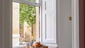 A small room with a window, a radiator, and two stools. - Luxury Apartment Next to Bath Abbey & Shops (Bath)