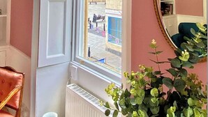 A room with a large window, a mirror, a radiator, and a chair. - Luxury Apartment Next to Bath Abbey & Shops (Bath)