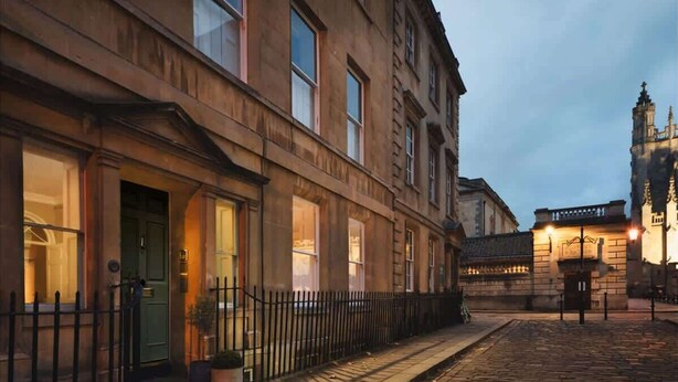 A historic building with a cobblestone street, a green door, and a small lamp post. - Luxury Apartment Next to Bath Abbey & Shops (Bath)