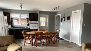 A compact living space with a dining area, kitchen, and seating area. - Great Escape Cabins: Cabin 5 (Alban)