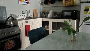 Una cocina con estufa, microondas y una mesa con una planta.