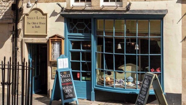 Ein historisches Gebäude mit einem Schild, auf dem steht: Sally Lunn's Das älteste Haus in Bath 1882.