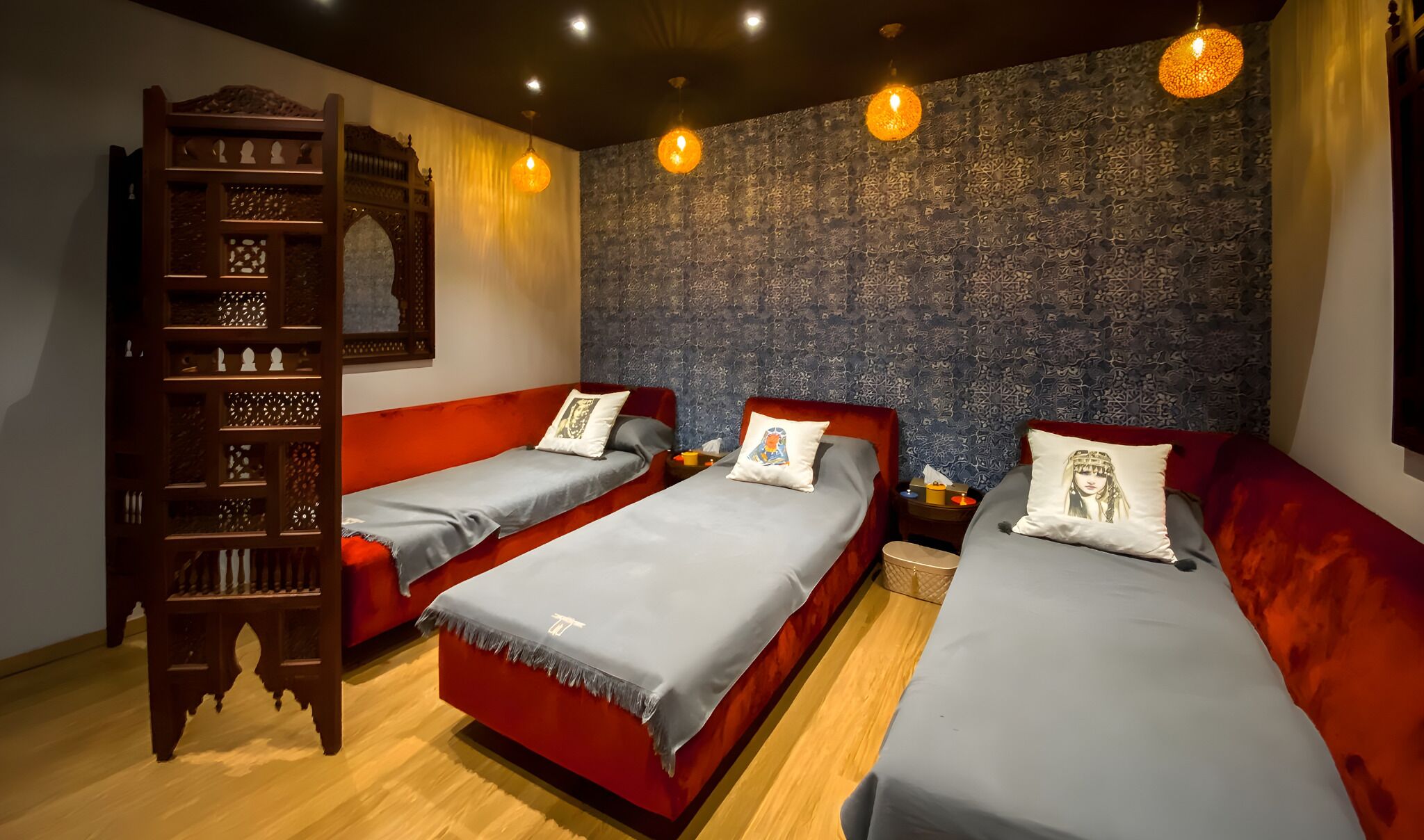 A room with two single beds, a wooden ladder, and a textured wall.