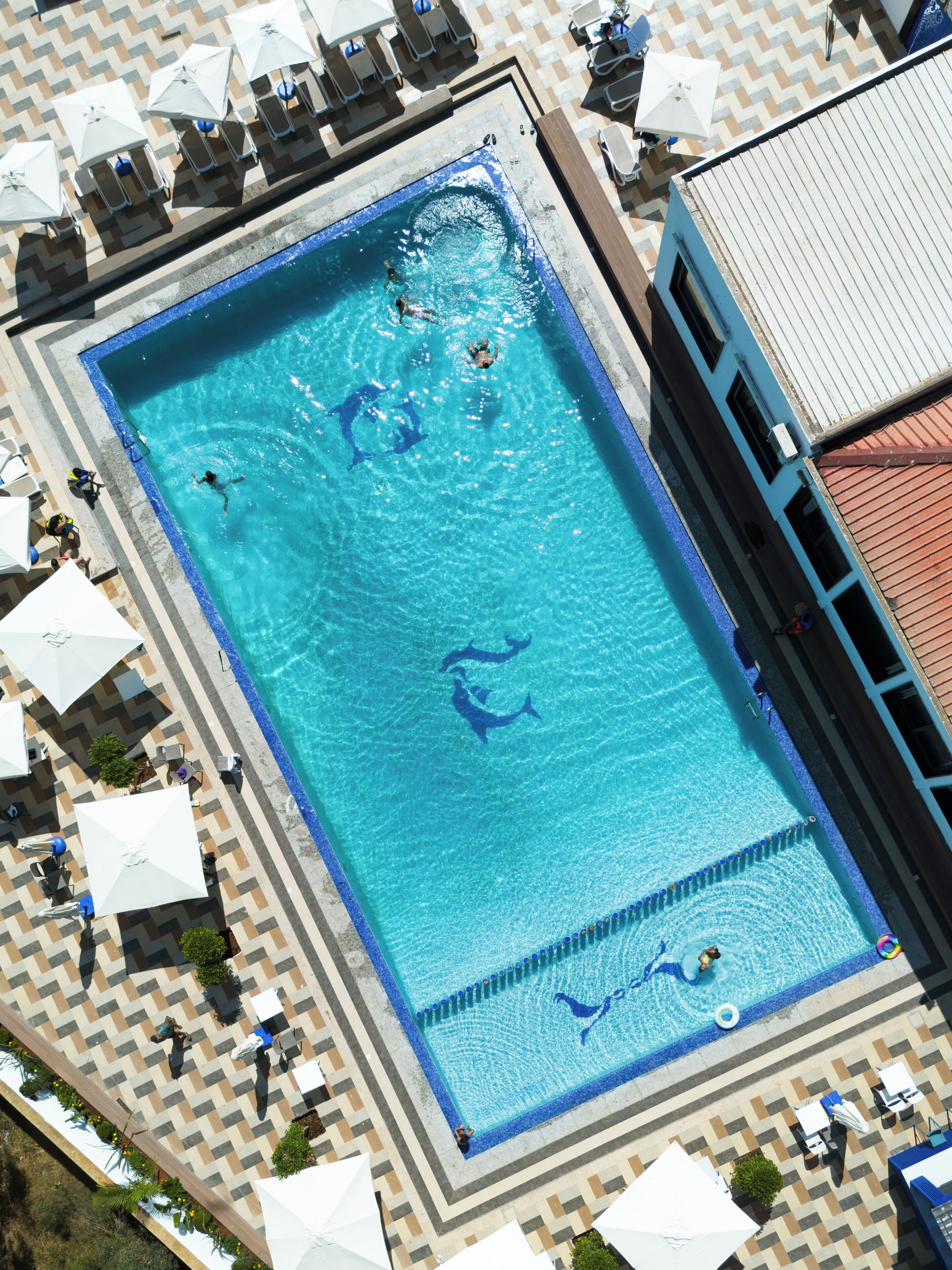 Una piscina al aire libre de temporada, sombrillas