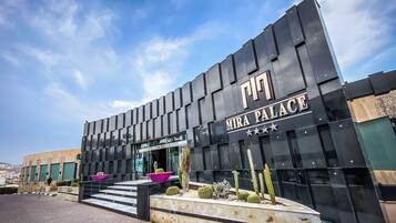 En modern byggnad med en svart fasad och namnet ”MIRA PALACE” tydligt synligt.