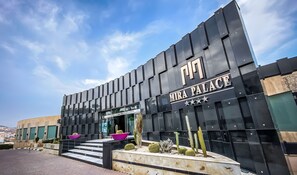 A modern building with a black facade and the name "MIRA PALACE" prominently displayed. - Mira Palace Hotel (Al Hoceima)