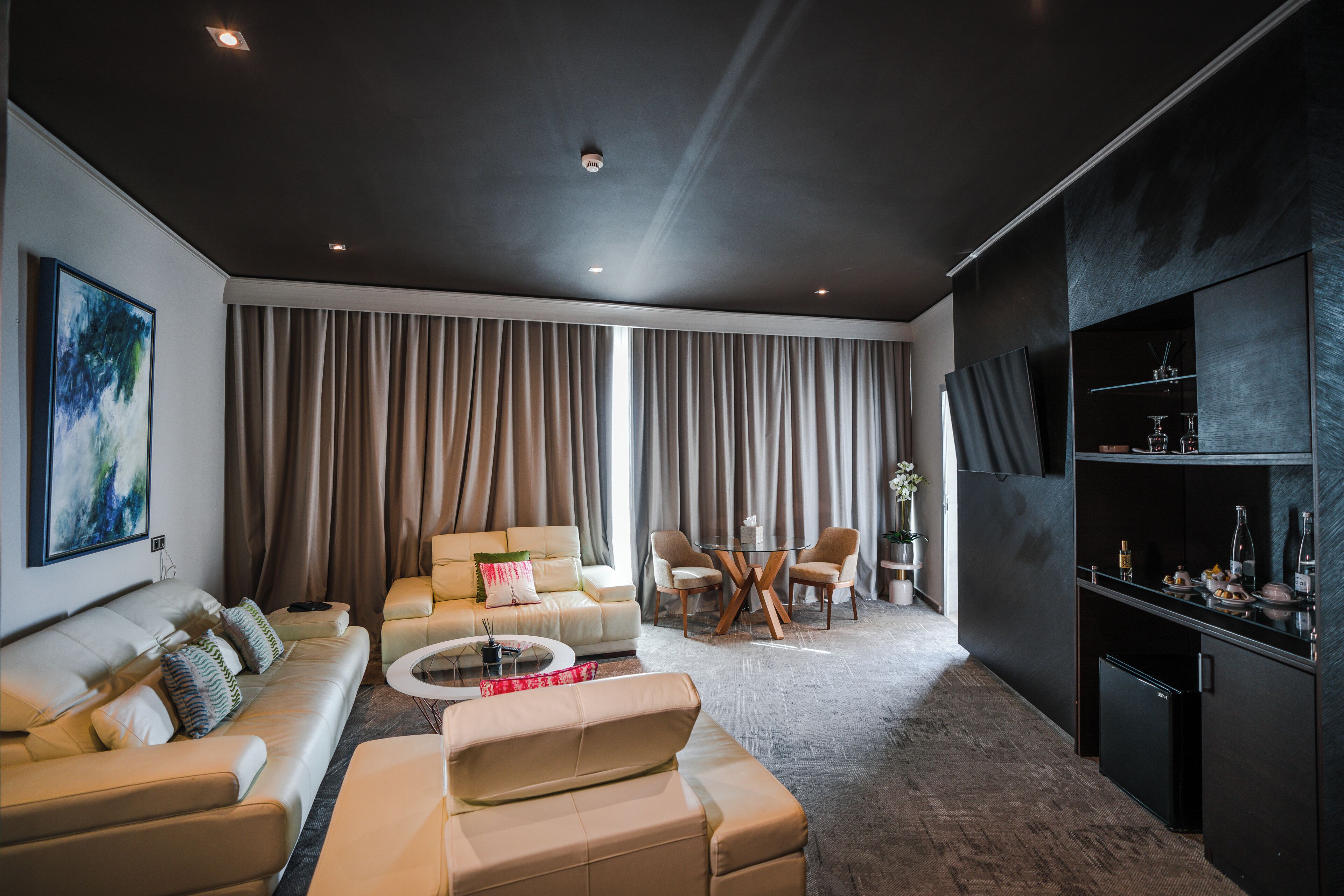 A modern living room with a sofa, coffee table, and dining area.