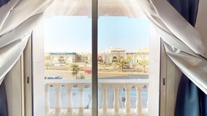 Un balcón con vista a una zona comercial, que incluye un edificio grande con múltiples arcos y un letrero de McDonald's.