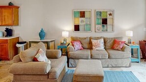 A living room with a sofa set, ottoman, and a small table with a lamp. There is a cabinet and a decorative wall piece. - 🌴Walk to Beach-3BR-Lake View-Seagrove Highlands 1304🌴 (Santa Rosa Beach)