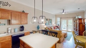 A spacious kitchen with wooden cabinets, a dining area with a table and chairs, and a living room with a sofa and a ceiling fan. - 🌴Walk to Beach-3BR-Lake View-Seagrove Highlands 1304🌴 (Santa Rosa Beach)