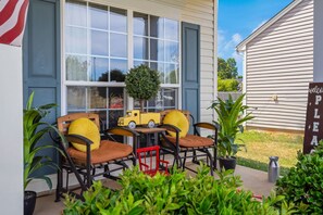 Un patio con mobiliario exterior, una mesita y un camión de juguete.