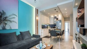 A modern living room with a sofa, coffee table, and dining area. - Mediteranean Luxury Apartment (Chania)