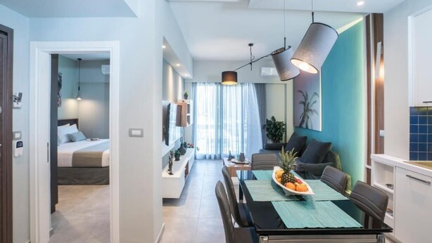 A modern apartment with a dining area, a kitchen, and a bedroom. - Mediteranean Luxury Apartment (Chania)