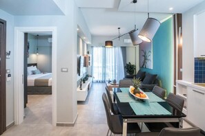 A modern apartment with a dining area, a kitchen, and a bedroom. - Mediteranean Luxury Apartment (Chania)