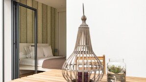 Ein Zimmer mit einem Bett, einem Holztisch mit einer dekorativen Metalllampe und einer Glasvase mit einer Pflanze.