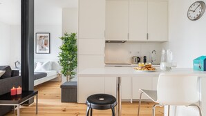 Una sala de estar moderna con un sofá, una mesa de centro con velas y una planta en maceta.