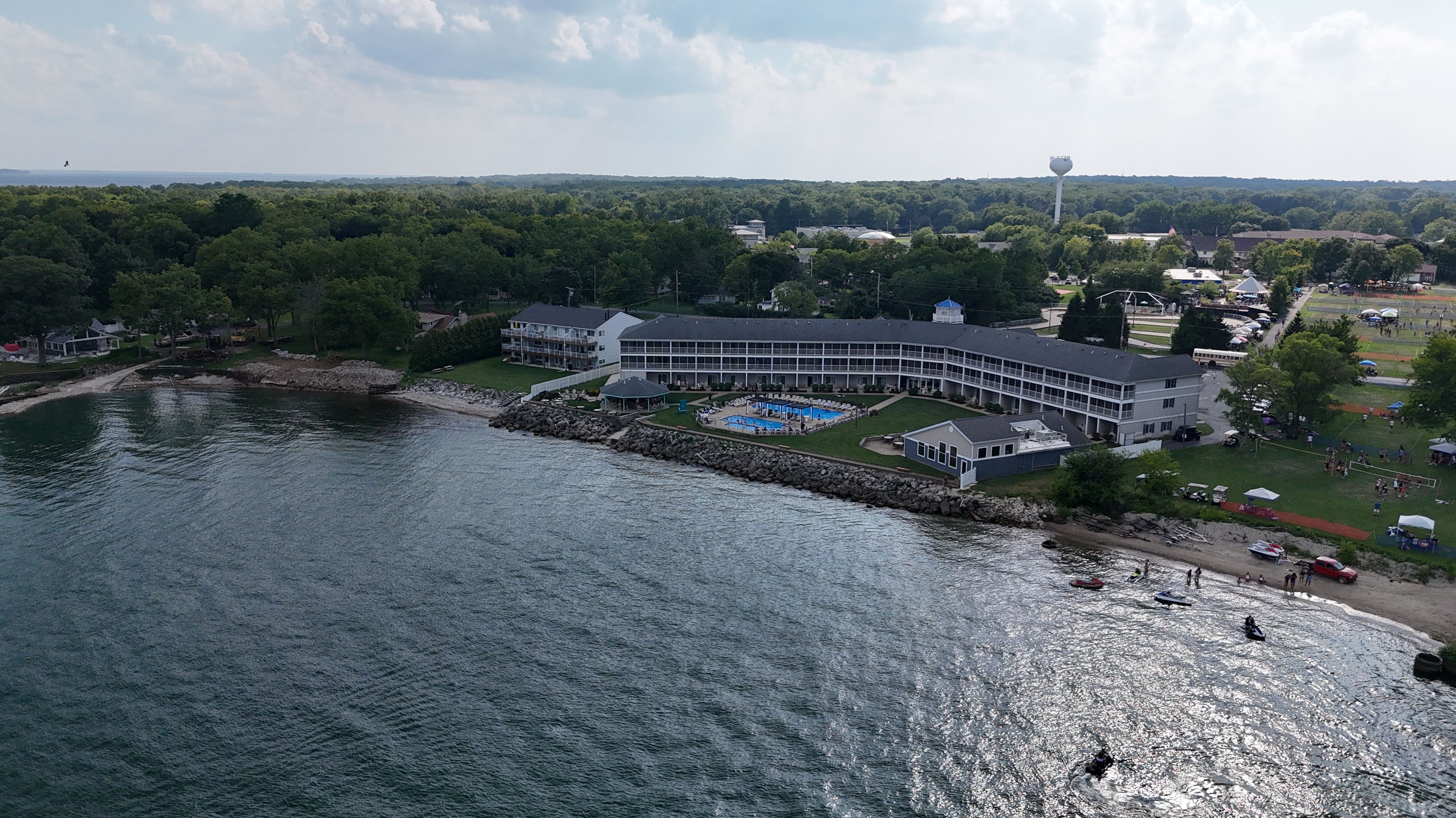 Un hôtel situé au bord de l’eau, doté d’une piscine, d’un quai et offrant une vue sur la forêt environnante.
