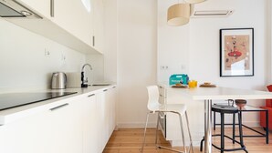A modern kitchen with white cabinetry, a coffee maker, and a bar stool. - Belem Design 08 by Homing (Lisbon)