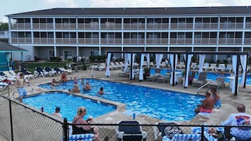 Ein Poolbereich mit Liegestühlen und einer überdachten Sitzgelegenheit.